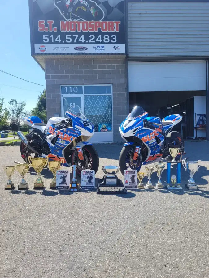 Deux motos de course bleues et blanches avec des trophées