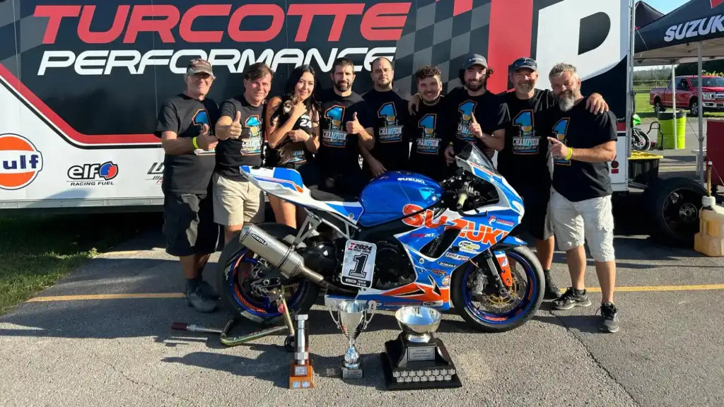 Équipe de course avec moto et trophées.