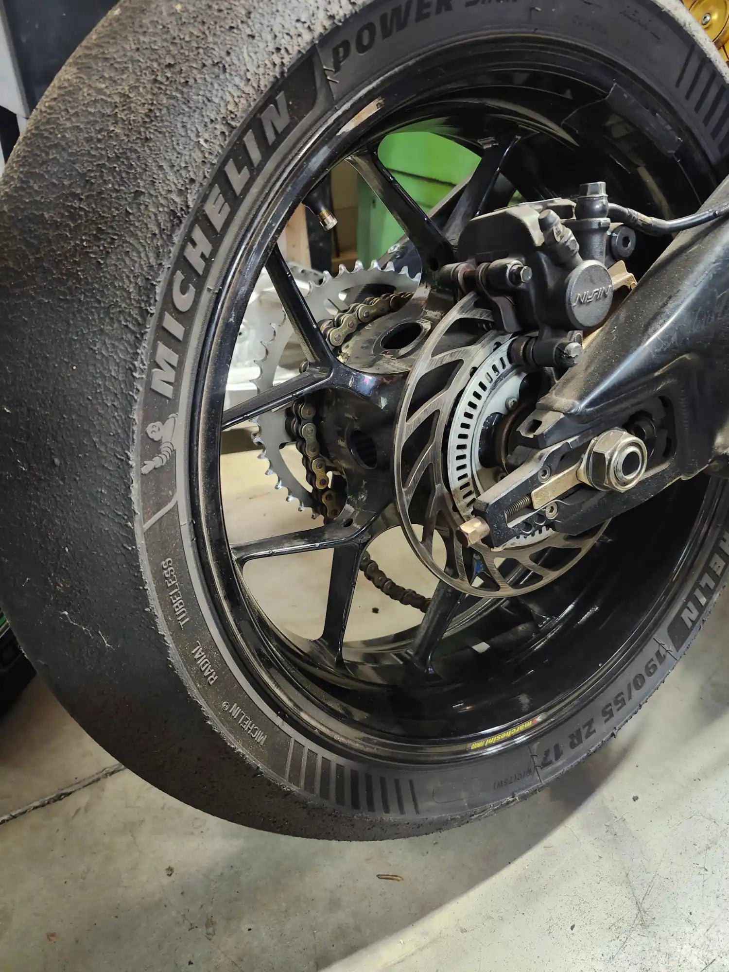 Roues arrière de motocyclette avec un pneu Michelin monté sur une jante noire.