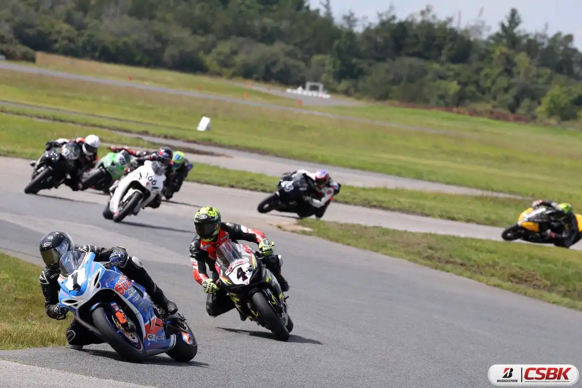 Des coureurs de motos qui s'affrontent sur une piste de course lors d'une compétition.